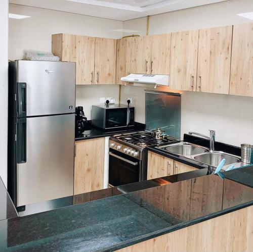a kitchen with a stainless steel refrigerator and a sink at Lux High Rise Marina Apartment in Dubai