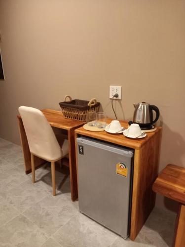 eine Küche mit einem Tisch und einem Kühlschrank neben einem Tisch in der Unterkunft Koh Kood Club in Ko Kood
