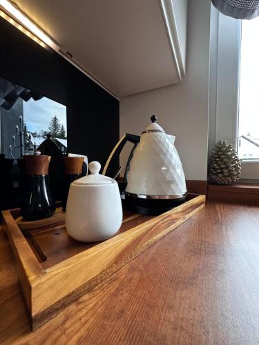 a table with two vases sitting on a wooden tray at Apartamenty Alcatraz z jacuzzi in Karpacz