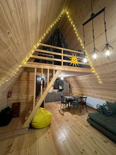 a large room with a wooden ceiling with a wooden table at Borjomi Story in Borjomi