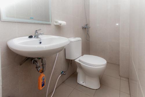 a bathroom with a toilet and a sink at Urbanview Hotel Priority Samarinda by RedDoorz in Samarinda