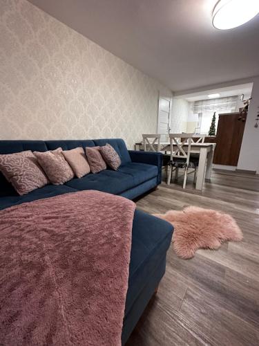 a living room with a blue couch and a table at Apartamenty Alcatraz z Jacuzzi in Karpacz