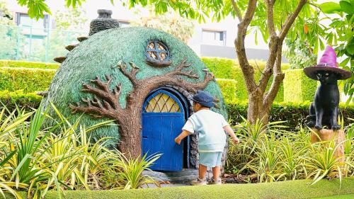 a young boy standing in front of a play house at SO/ Sofitel Hua Hin in Cha Am