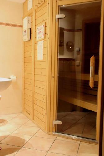a bathroom with a shower with a glass door at 4 Sterne Apartment Kormoran mit Terrasse und Sauna in Lobbe