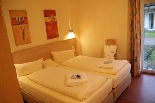 Dos camas en una habitación de hotel con toallas encima. en 4 Sterne Apartment Ruden mit Sauna und Terrasse, en Lobbe