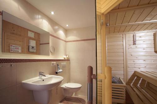 La salle de bains est pourvue d'un lavabo et de toilettes. dans l'établissement 4 Sterne Apartment Dünensand Sauna und Terasse in Südwestlage, à Lobbe
