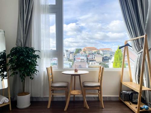 a table and two chairs in front of a window at Nai Homestay 2 in Da Thanh