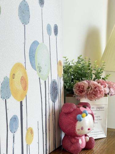 a stuffed teddy bear sitting on a table with flowers at Nai Homestay 2 in Da Thanh