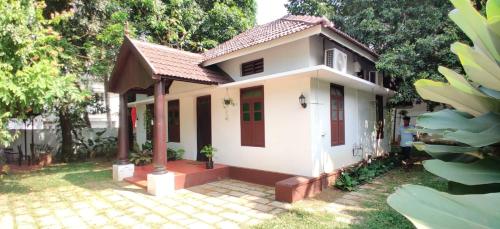 a small white house with a red door at Lannister Inn in Cochin