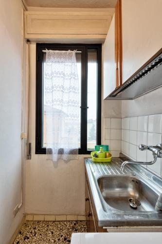 uma cozinha com um lavatório e uma janela em Easy Old City Apt Venice em Marghera
