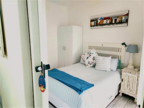 a small bedroom with a white bed and a mirror at Sea Scapes Holiday Apartment in Margate