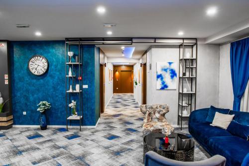 a living room with a couch and a clock on a wall at Hotel Biss in Zenica