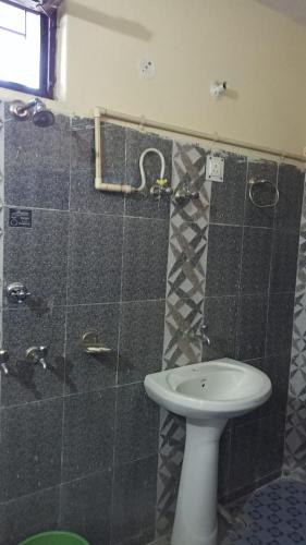 e bagno con servizi igienici, lavandino e doccia. di Hotel Gauri Shankar Palace Murari a Barkot