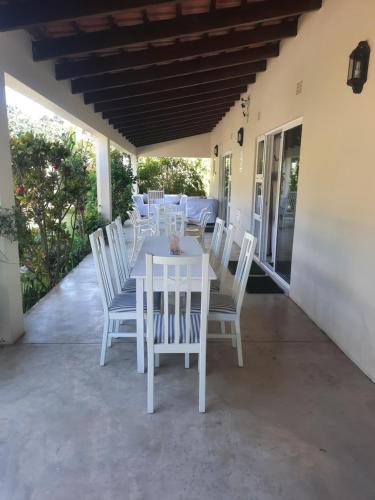 a white table and chairs on a patio at Tropicana Guesthouse in Ponta do Ouro