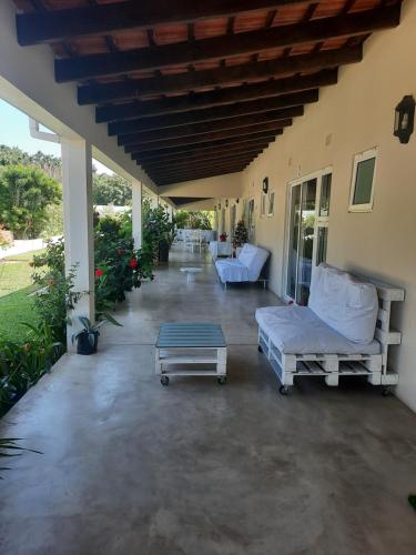 - une terrasse couverte avec 2 canapés et une table dans l'établissement Tropicana Guesthouse, à Ponta do Ouro