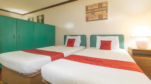 two beds in a room with green cabinets at RedDoorz at Broadway Court Apartelle II Quezon City in Manila