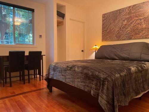 1 dormitorio con 1 cama y 1 mesa con sillas en The Groves at Redway Beach - Craftsman, en Redway