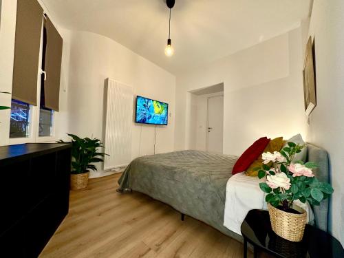 a bedroom with a bed and a tv on the wall at Luxury Suites Mons in Mons