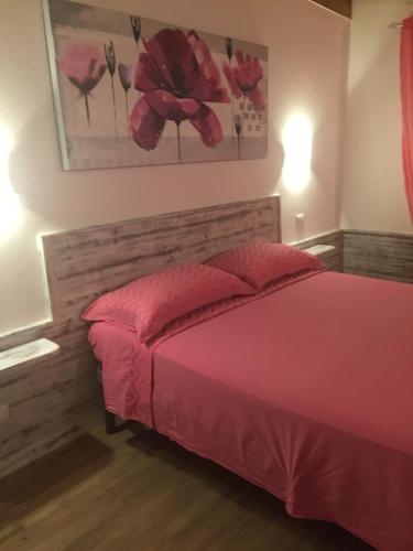 a bedroom with a bed with a pink bedspread at Aquila Di Mare in Fiumicino
