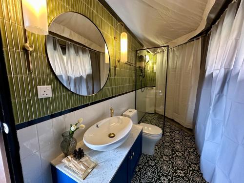 un bagno con lavandino, water e specchio di kMah@SomerMansion a Tanah Rata