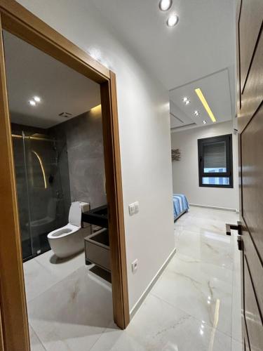 een badkamer met een toilet en een glazen deur bij Chez Nissrine in Tetouan