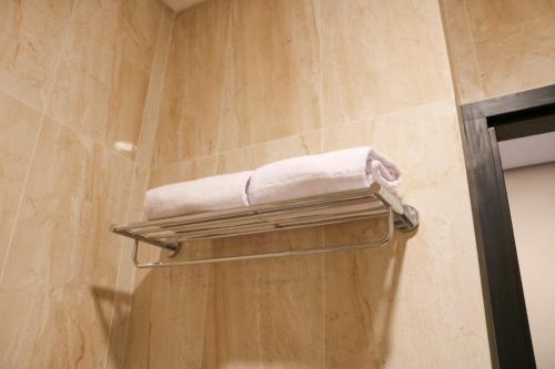 een handdoekenrek in een badkamer met douche bij Grand Ametis Hotel Jakarta in Jakarta