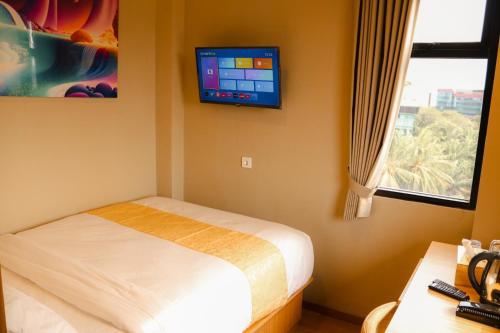 雅加達的住宿－Grand Ametis Hotel Jakarta，卧室配有一张床,墙上配有电视。