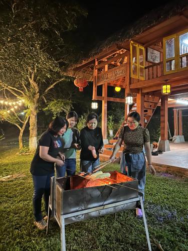 a group of people standing around a grill at Pài Bjooc homestay in Làng Mán