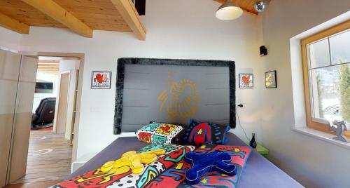 a bed with colorful pillows on it in a room at Zillertal Residenz in Ginzling