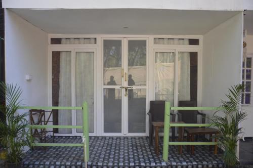 a front porch with two chairs and a door at SUNBATH beach EXOTICA in Canacona