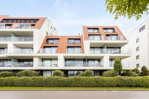 un edificio de apartamentos con arbustos delante de él en Ruim en modern appartement ideaal gelegen tussen zee en jachthaven, en Nieuwpoort