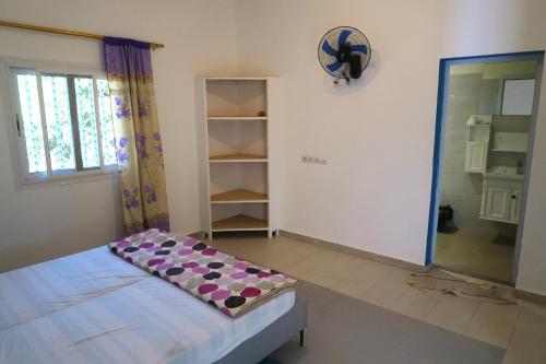 Habitación con cama y reloj en la pared en Chez Fatou et Saladin, 