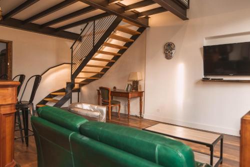 - un salon avec un canapé vert et une télévision dans l'établissement Loft Design Centre Ville avec Clim, à Orange