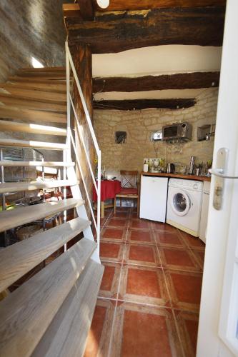 a kitchen with a staircase and a washing machine at Le Pigeonnier - Piscine - Jardin - Calme in Labastide-de-Lévis