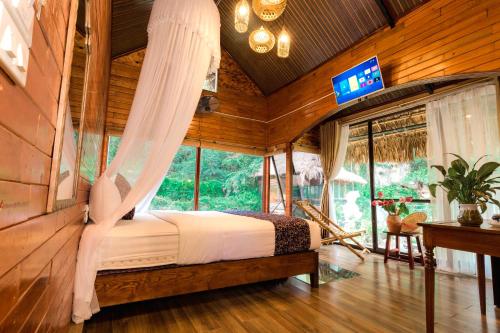 1 dormitorio con 1 cama y TV en una habitación en Tam Coc Lion Kings Hotel & Resort, en Ninh Binh