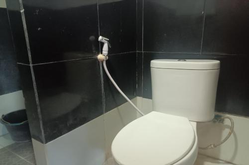 查亞普拉的住宿－OYO 93485 Hotel Kenzie Sentani，一间带卫生间和软管的浴室