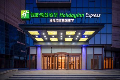 een toegang tot een gebouw met een bord erop bij Holiday Inn Express Weifang City Center, an IHG Hotel in Weifang