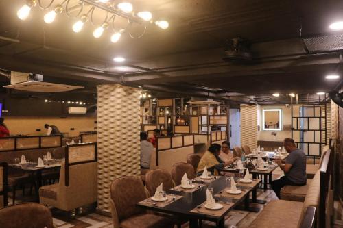 贾巴尔普尔HOTEL KADAMB TREE的一群人坐在餐厅的桌子旁
