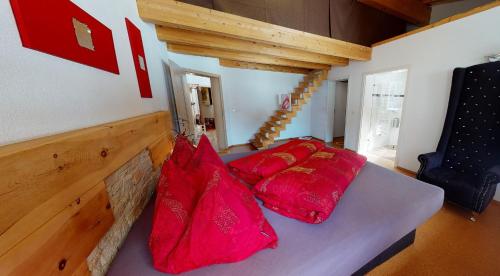 Habitación con sofá y almohadas rojas. en Zillertal Residenz, en Ginzling