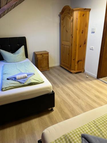 a bedroom with a bed and a wooden cabinet at Gasthof Löwen in Pfronten