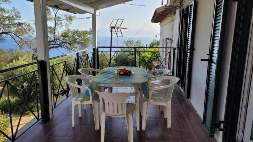 einen Tisch und Stühle auf dem Balkon eines Hauses in der Unterkunft Villa Korakades in Korakádes