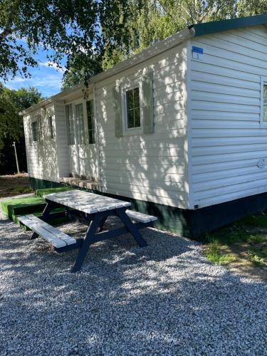 a picnic table in front of a white cabin at SuliCamp Kompleks Wypoczynkowy in Sulistrowice