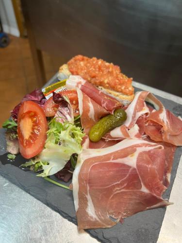 a plate of food with meat and vegetables on a table at Hotel Mirtil in Pas de la Casa