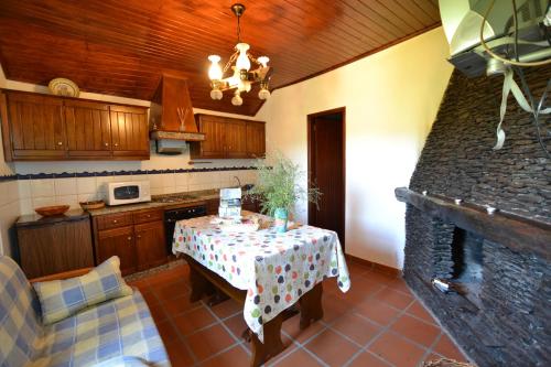 a kitchen with a table and a kitchen with a stove at Branda da Aveleira in Branda da Aveleira