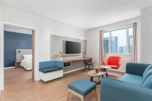a hotel room with a couch and a bed and a tv at Holiday Inn Express Weifang City Center by IHG in Weifang