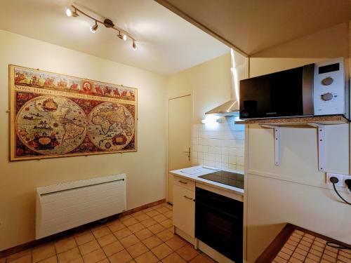 une petite cuisine avec un réfrigérateur et un micro-ondes dans l'établissement Charmant gîte avec terrasse, poêle à bois et parking privé près de la Creuse et d'Argenton-sur-Creuse - FR-1-591-564, à Le Menoux