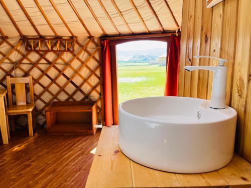 a bathroom with a tub in a yurt with a window at ViaVia Harganat Lodge 
