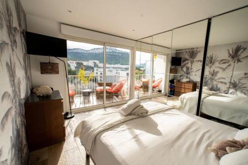 a bedroom with a large bed and a balcony at Suite vue sur mer in Marseille
