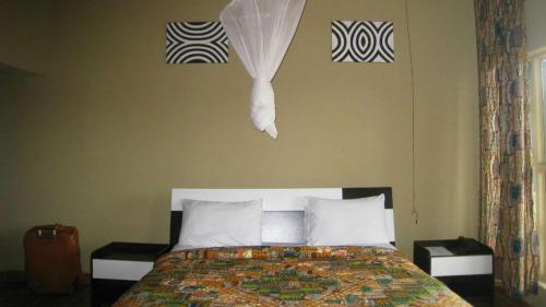 1 dormitorio con 1 cama y toallas en la pared en Nyungwe Hill View Hotel en Rwumba