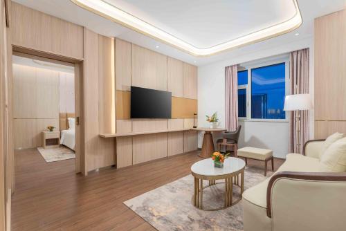 a living room with a couch and a tv at Holiday Inn Express Weifang City Center by IHG in Weifang